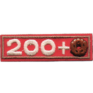 A rectangular embroidered patch with a red background and tan border, displaying "200+" in cream thread, with the zero on the right replaced by a brown donut-shaped design.
