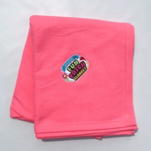 A folded Carolina Blue Patch Blanket with a colorful patch reading "Official Fun Patch Blanket," surrounded by small flower designs, displayed on a plain white background.