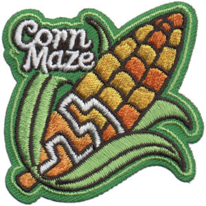 The Corn Maze Patch features an embroidered corn cob with a zigzag maze and green husk, plus "Corn Maze" stitched in white in the upper left corner.