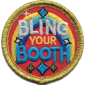 The Bling My Booth Patch (Copy) is a round embroidered patch with a yellow border, showing "BLING YOUR BOOTH" in bold, colorful letters on a red background decorated with stars, diamonds, and a rainbow pattern.