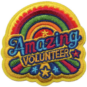 A vibrant embroidered patch called "Star Volunteer Patch (Copy)" features a rainbow, stars, "Amazing Volunteer" in blue and yellow letters, and a yellow border.