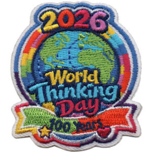 The 2026 World Thinking Day embroidered patch showcases "2026" above a globe, "World Thinking Day" in the center, and "100 years" on a rainbow banner at the bottom in a bright, colorful design.