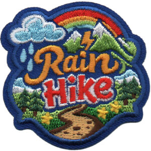 Embroidered patch with rainbow, cloud, raindrops, lightning, mountains, trees, and a winding trail, featuring "Winter Hike Patch (Copy)" in large letters at the center.