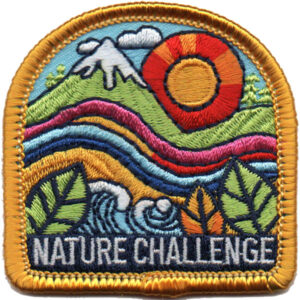The Outdoor Explorer Patch (Copy) features an embroidered landscape with mountains, a sun, colorful wavy land and water, green leaves, and “NATURE CHALLENGE” at the bottom, all bordered in gold.