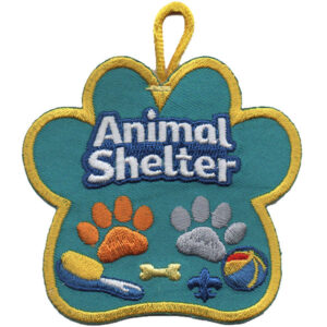 The Animal Shelter Patch features white "Animal Shelter" text, orange and gray paw prints, a brush, bone, and ball on a blue background with yellow trim and a hanging loop.