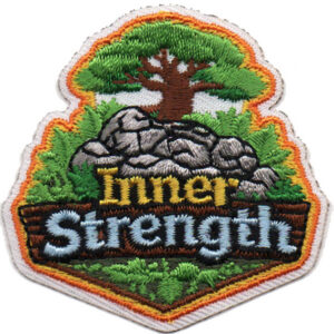 The Inner Strength Patch (Copy) features an embroidered tree growing from rocks, with "Inner Strength" in yellow and blue lettering, surrounded by grass and finished with a brown border.