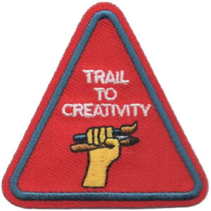 The Bright and Bold Patch features a red triangle with a blue border, showing a yellow hand holding a pencil and paintbrush, plus "TRAIL TO CREATIVITY" embroidered above in white.