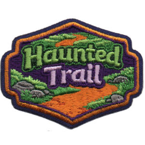 The Haunted Trail Patch features "Haunted Trail" in green and purple text, a winding orange path, green grass, gray rocks, and a purple background with a dark blue and orange border.